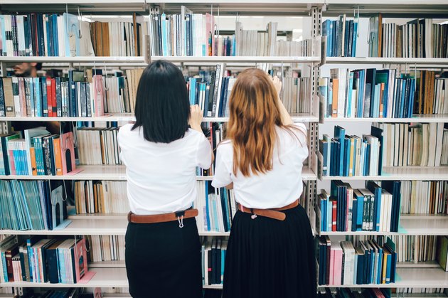 Two women searching for books in the library