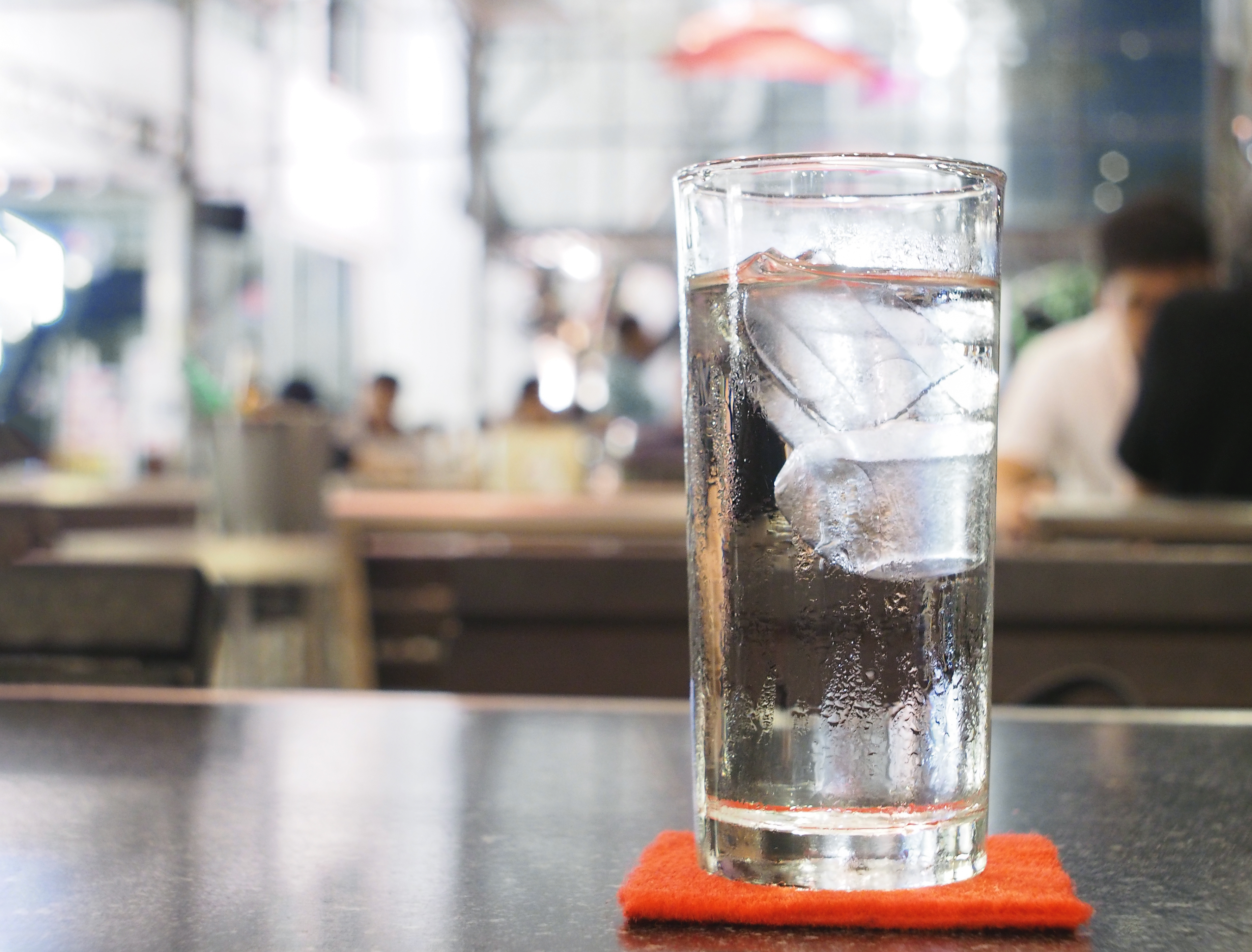 Лед всплывает в воде. Стакан воды в кафе. Вода со льдом. Ресторан на воде. Лед в стакане.