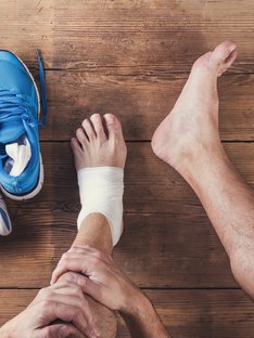 Man with an exercise injury near his ankle, workout injury prevention concept