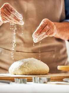 Hands preparing dough in kitchen for bread