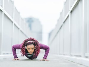 坚定的体育女人在城市做俯卧撑