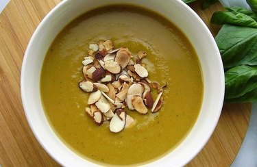 Top view of a bowl of green Vegan Power Soup topped with sliced almonds