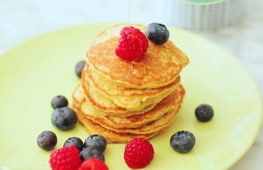 Pancake stack with berries on lime green plate