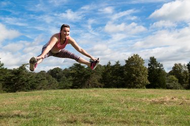 Brittany does a split jump outside.