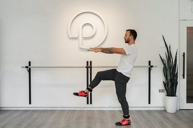 Man Doing Standing Forward Toe Tap and Squeeze With Resistance Band