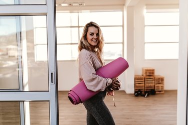 woman holding yoga mat