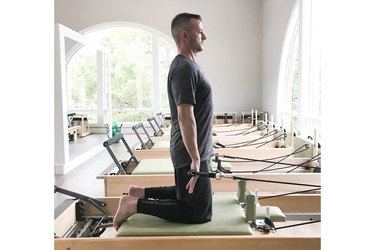 man performing chest expansion pilates exercise