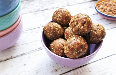 Pecan pie protein balls in a purple bowl over wooden background.