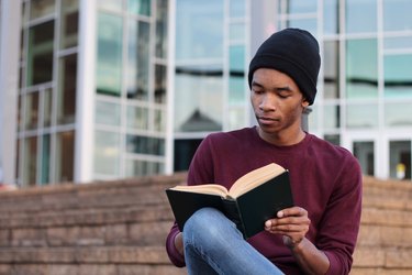 man reading book outdoors