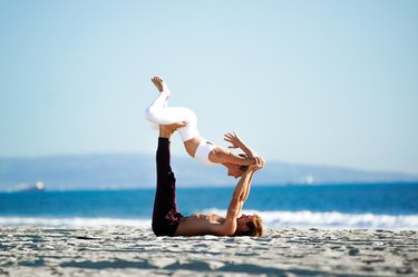 沙滩上的一对Acroyoga情侣。