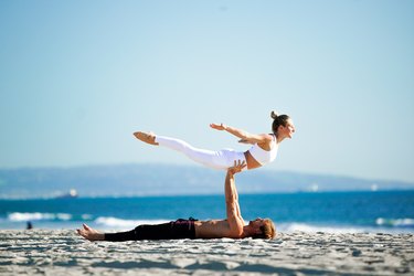 Person performing back extension on partner's hands.