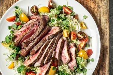 A Whole30 Diet dinner of steak over salad