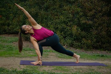 Woman performing yoga pose outdoors.