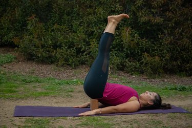 Woman performing restorative yoga posture.