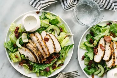 healthy chicken recipe of green salad topped with grilled chicken