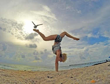 Keri Verna in handstand pose on the beach
