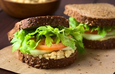 Smashed chickpea sandwich on a tan placemat