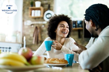 happy couple eating a healthy filling breakfast to avoid overeating later