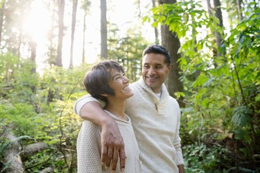 smilling woman and man in lush forest hiking