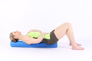 woman lying on foam rollers demonstrating rebalance exercise for MELT method