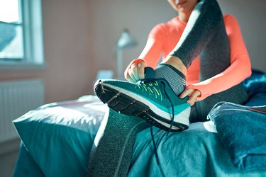 Woman wearing running socks and putting on her running shoes