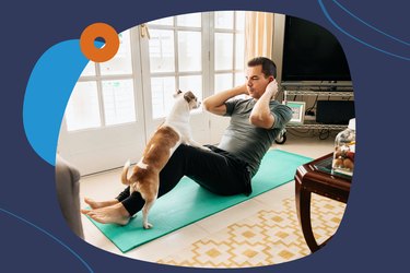 man doing sit-ups with his dog at home on exercise mat