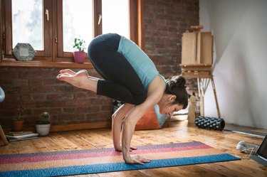 Woman doing crow yoga pose for balance