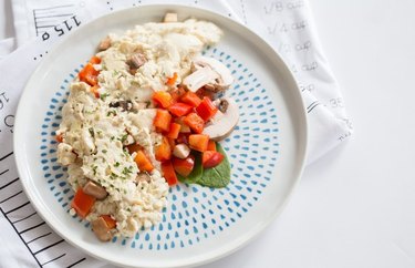 an overhead photo of a blue zone-inspired breakfast recipe for veggie tofu scramble on a white plate with blue dots