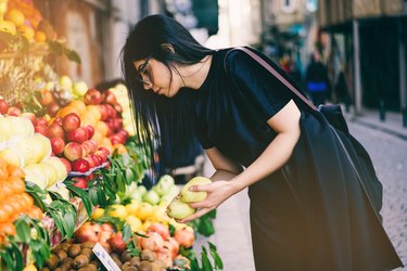 女人在农贸市场买水果和蔬菜