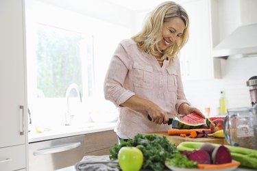 woman cutting fruits and vegetables in the kitchen