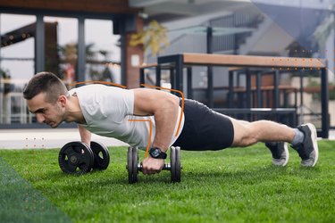 person doing a push-up renegade row with dumbbells during dumbbell challenge back and shoulder workout