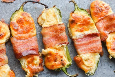 Keto bacon wrapped jalapeno poppers on grab background.