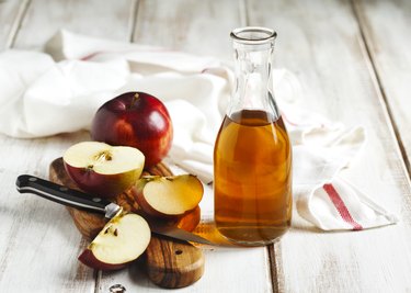 Apple cider vinegar with apples on a table