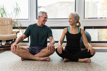 woman and man sitting cross legged after doing an at-home workout