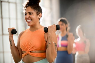 Woman lifting weights during Corepower Yoga workout class