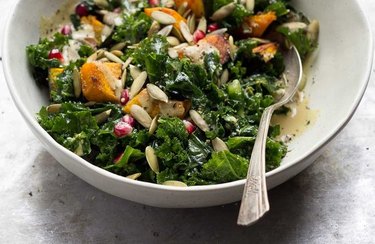 Wilted Kale Salad With Roasted Squash and Maple Dijon Dressing in a white bowl