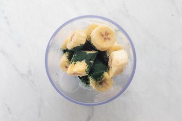 Bananas, coconut milk, spirulina and blueberries in blender