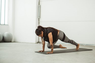 Woman doing mountain climbers or a knee-to-arm plank