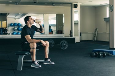 Man drinking muscle-building protein powder supplement after a workout