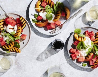 peach watermelon burrata salad in white bowls on tabletop