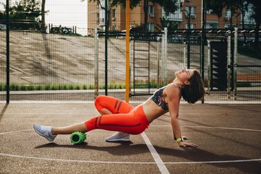 Woman foam rolling her calf muscle for post-marathon recovery