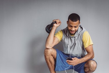 男人拿着kettlebell听练习音乐