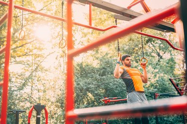 Man using rings for a playground workout.