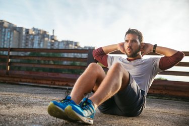 Man performing sit up exercise to reduce stomach size