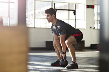 Man performing kettlebell deadlift.