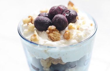 Breakfast Recipes for Longevity Nutty Berry Quinoa Parfait in a glass topped with blueberries