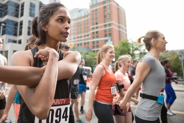 Woman stretching at the start line of a running race