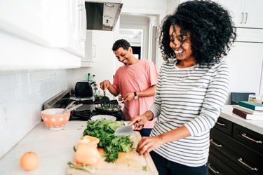 Couple using cooking tips and cooking hacks for healthy cooking in kitchen