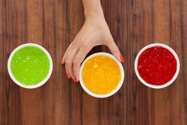 Woman's hand reaching for bowl of yellow Jell-O