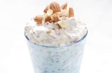 Almond and Yogurt Cereal in a glass over white background